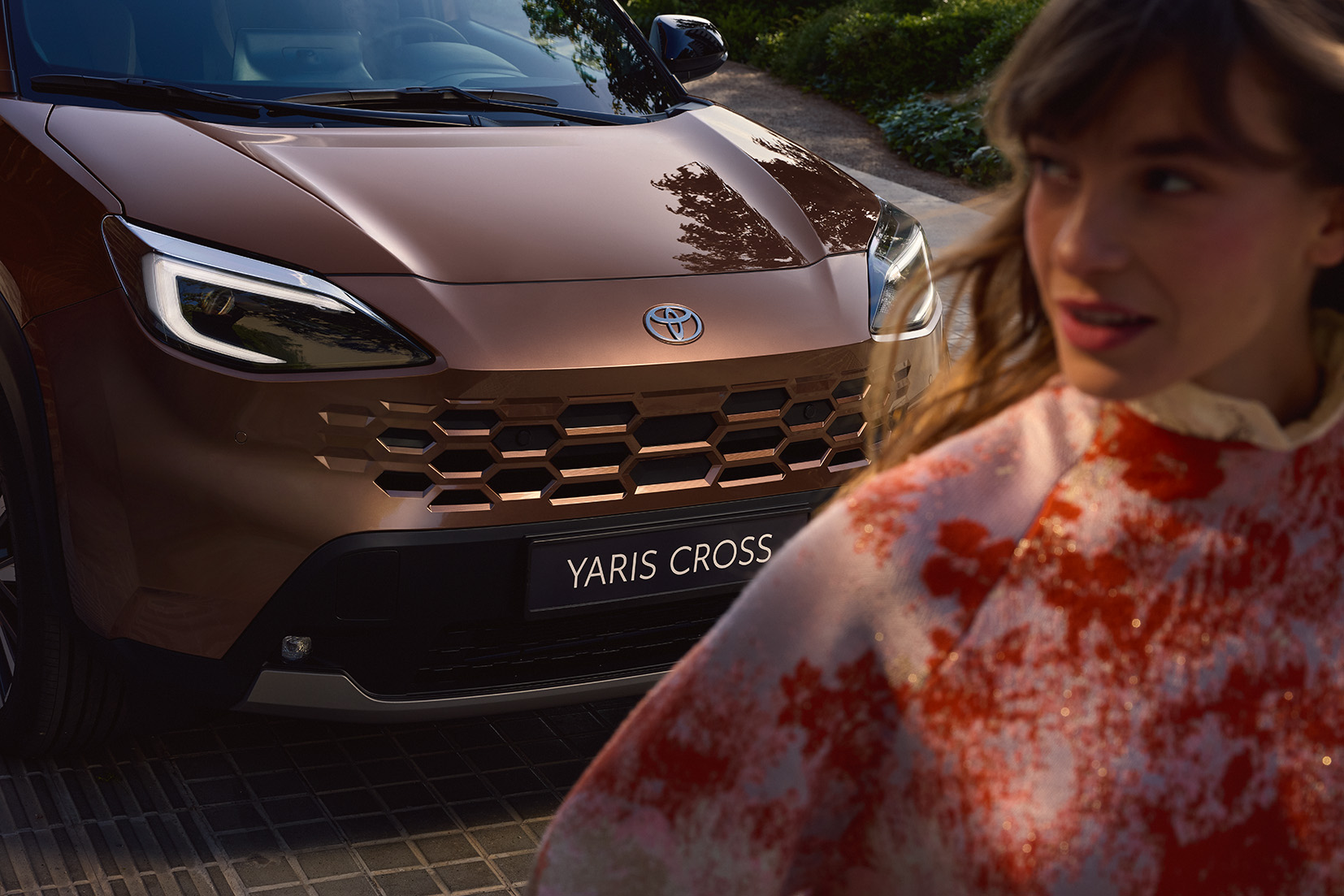 Zbliżenie na przedni reflektor i osłonę chłodnicy nowej Toyoty Yaris Cross